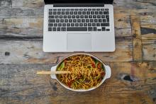 A plate of food in front of a laptop.