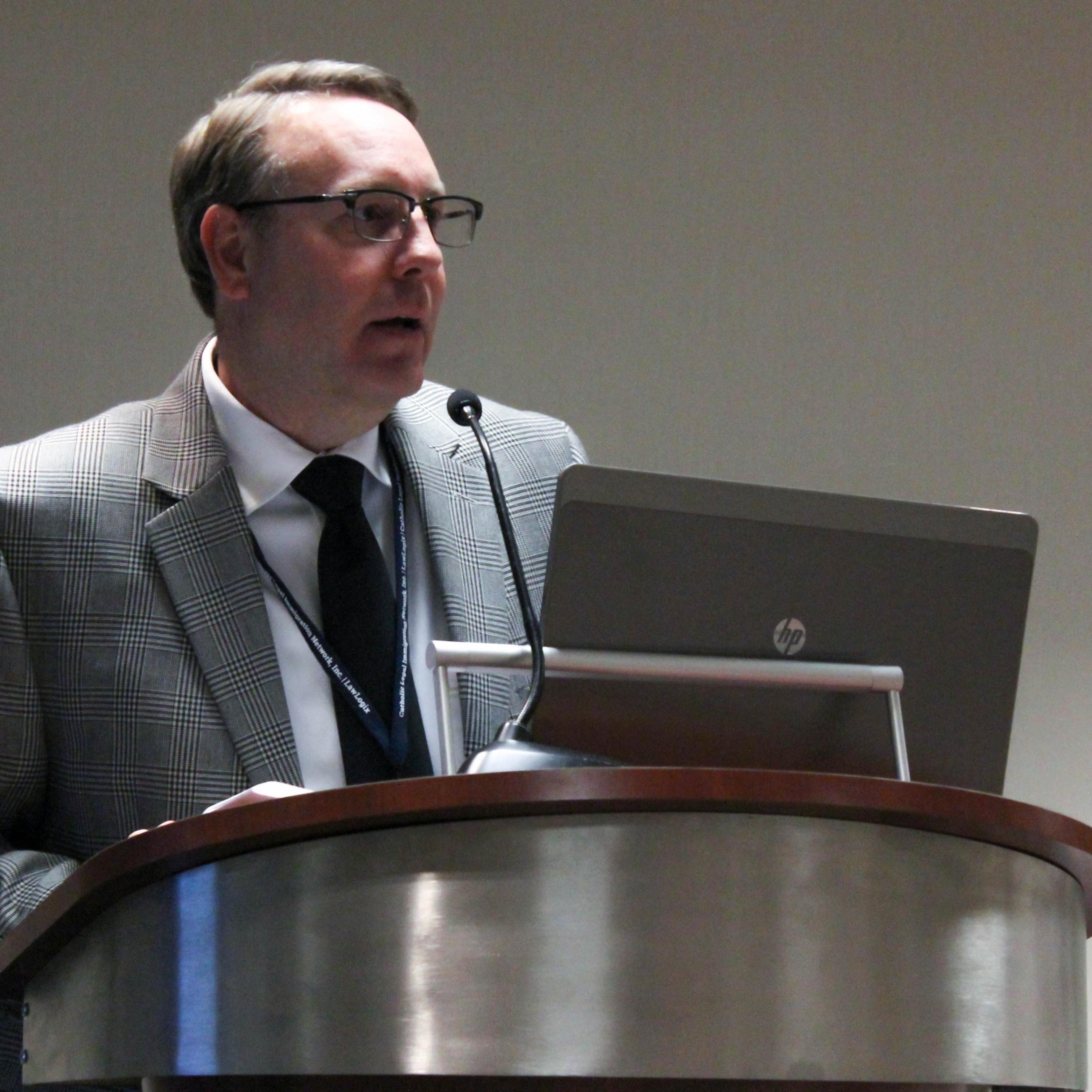 A man stands and speaks at a podium