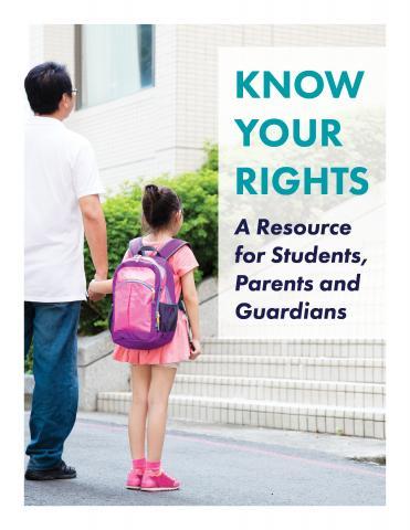 A man holding a girl's hand in front of a school.