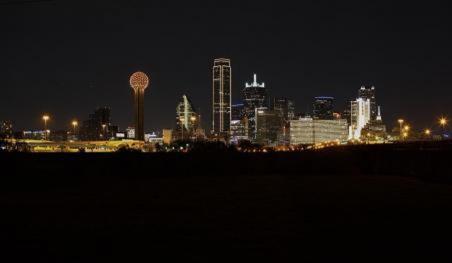 The Dallas skyline at night illuminated in gold.
