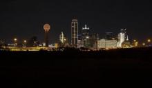 The Dallas skyline at night illuminated in gold. 